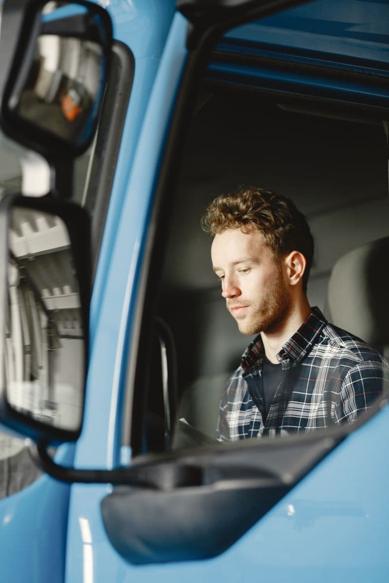 Driver in the cab of his truck checking before a run